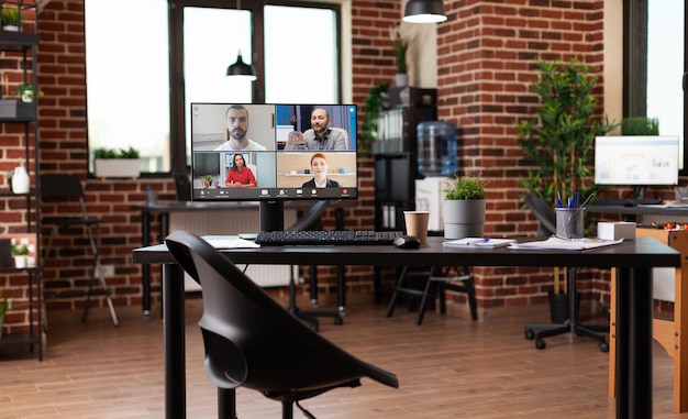 Free Photo monitor with video call conference on table in empty workplace. online business meeting with video conference on computer for remote communication with coworkers. teleconference call