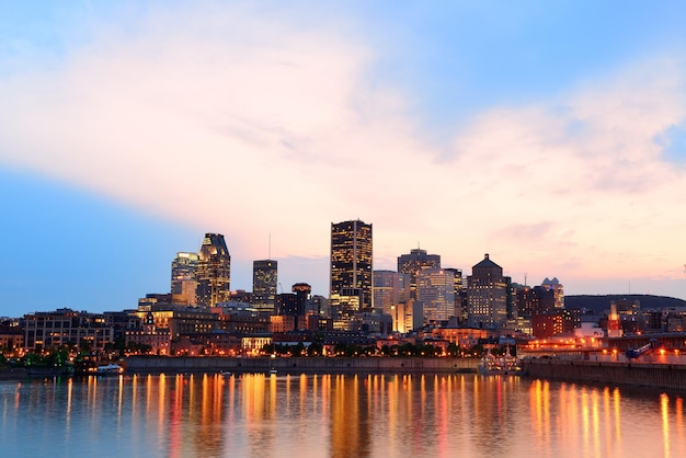 Montreal over river at sunset with city lights and urban buildings