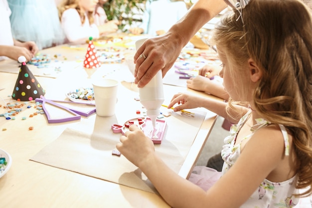 Free photo the mosaic puzzle art for kids, children's creative game. the hands are playing mosaic at table. colorful multi-colored details close up. creativity, children's development and learning concept