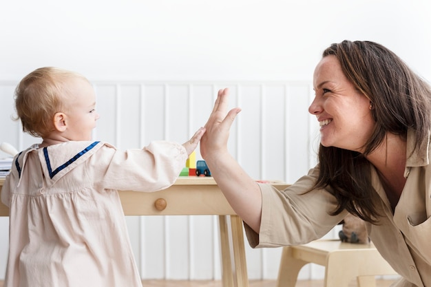 Free photo mother and baby daughter giving high fives