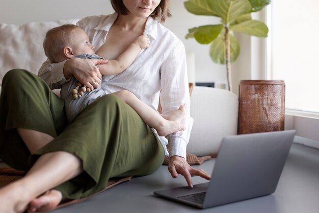 Mother breast feeding her child while working