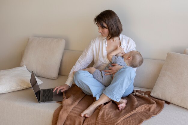 Mother breast feeding her child while working