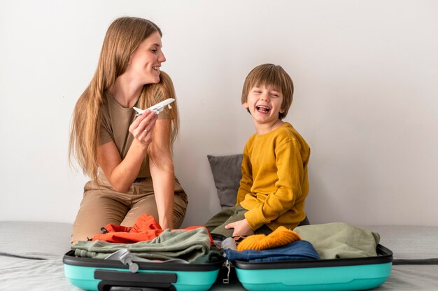 Mother and child at home with airplane figurine and luggage