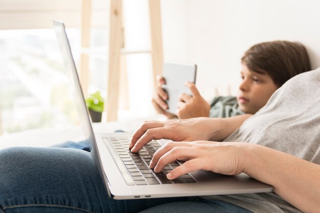 Mother and child looking on smart devices