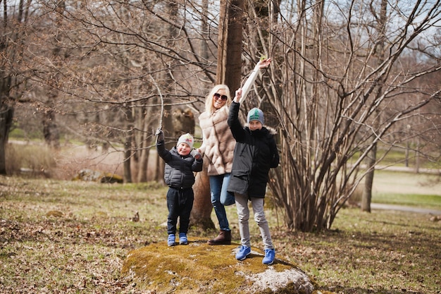 Mother and children playing on a stone