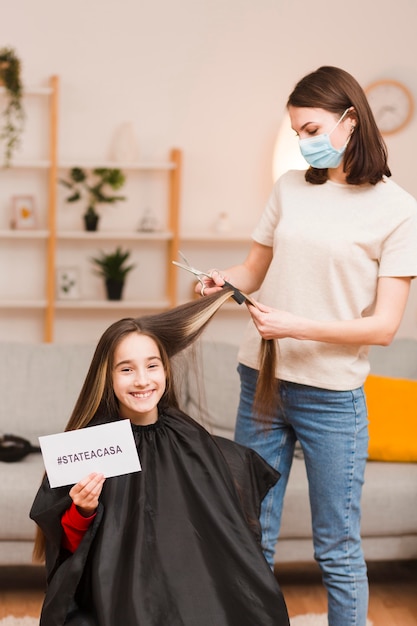 Mother cutting daughter hair