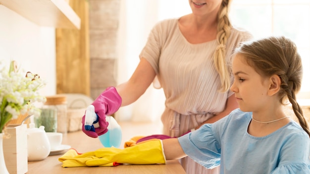 Mother and daughter cleaning the house