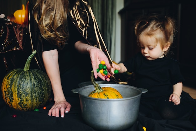 Mother and daughter decorating a pumpkin in a bowl