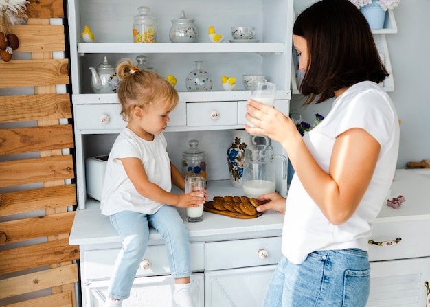 Mother and daughter drinking milk and eating cookies