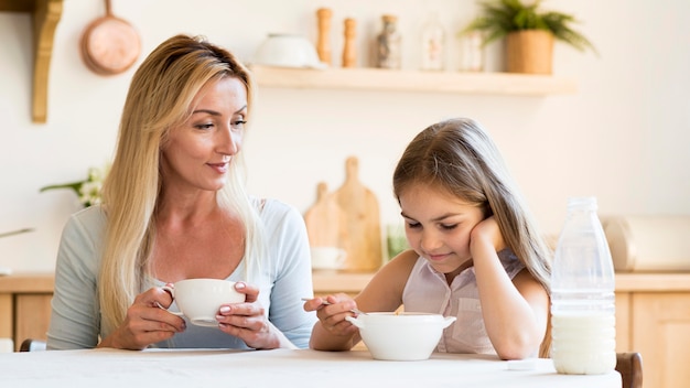 Free photo mother and daughter having breakfast together