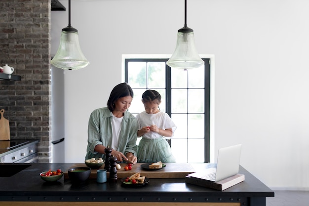 Mother and daughter having a video call from their kitchen