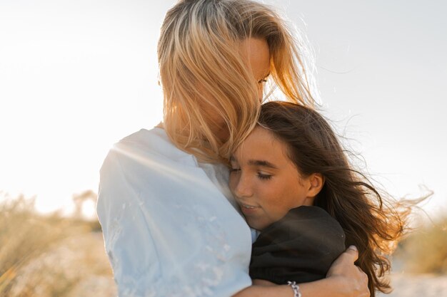 Mother and daughter hugging on the beach Mother's day love family parenthood childhood concept