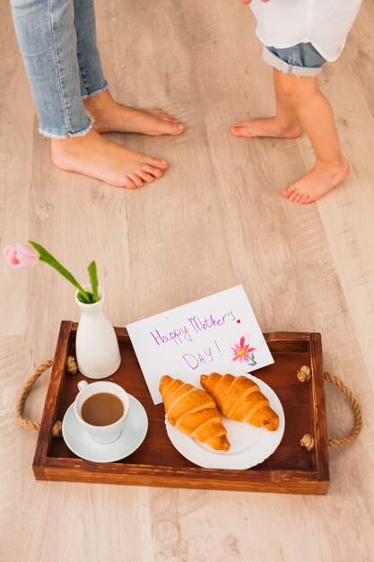 Mother and daughter near tray with Happy Mothers Day inscription