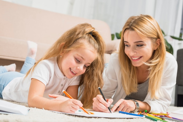 Mother and daughter painting on the floor