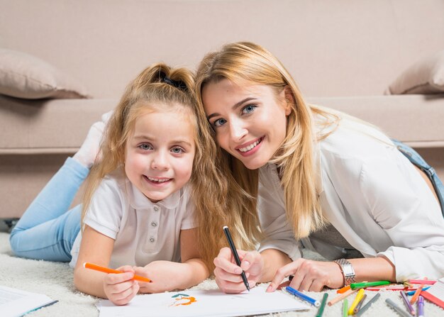 Mother and daughter painting on the floor