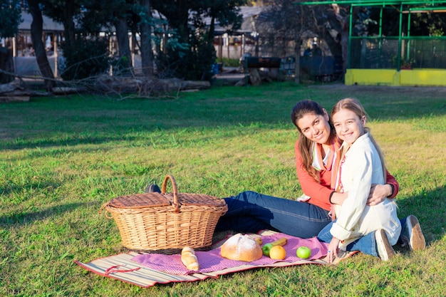 Free photo mother and daughter picnicking in the park