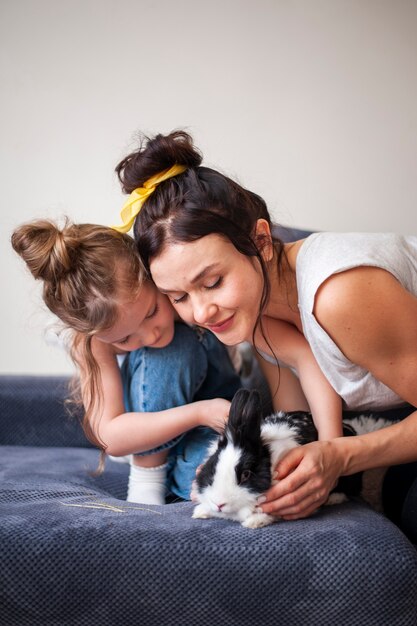 Mother and daughter playing with rabbit