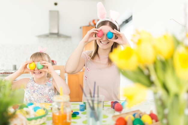 Mother and daughter posing with Easter eggs