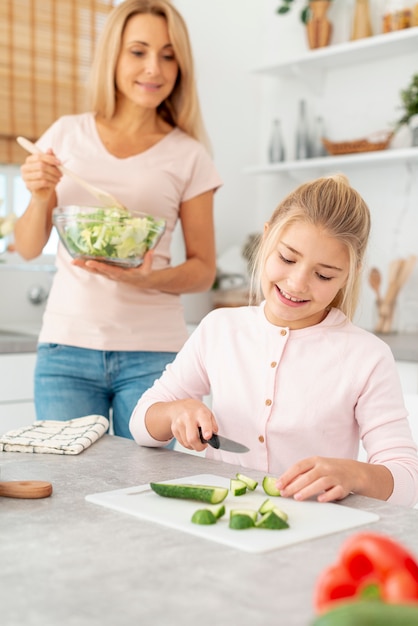 Free photo mother and daughter preparing salad