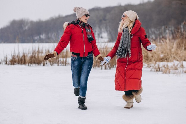 Mother and daughter running on lake in winter time