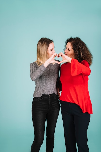 Mother and daughter showing heart gesture