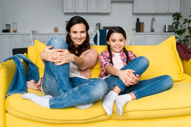 Mother and daughter sitting on the couch