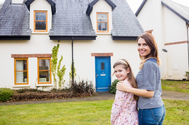 Mother and daughter standing in lawn