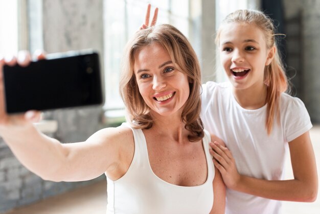 Mother and daughter taking funny selfie