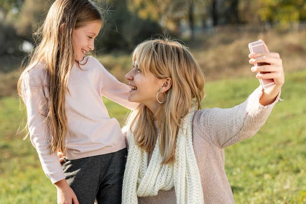 Mother and daughter taking selfies