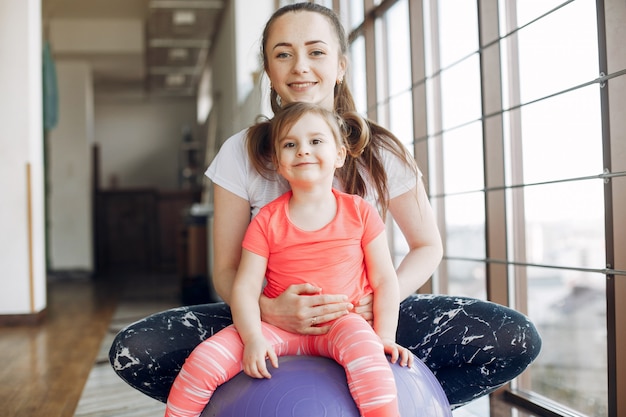 Free photo mother and daughter training in a gym