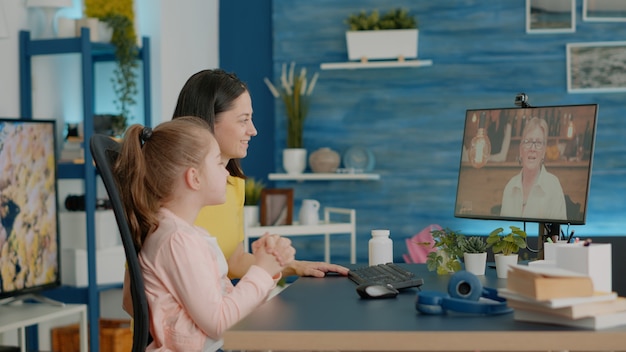 Free photo mother and daughter using video call for chat with grandmother