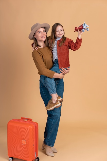 Mother and daughter with luggage ready for traveling