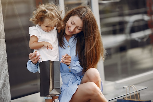 Free photo mother and daughter with shopping bag in a city