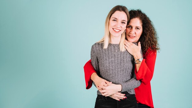 Mother embracing smiling daughter