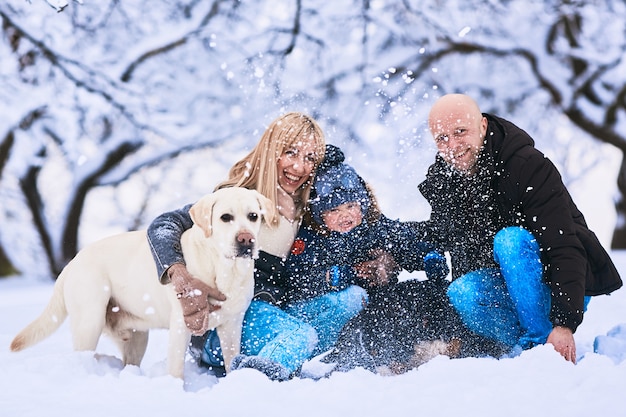 Free Photo the mother, father, son and dogs sitting on the snow