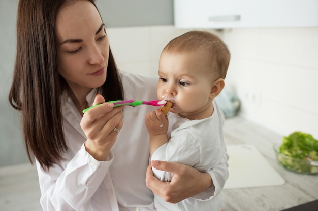 Mother feed cute baby with spoon