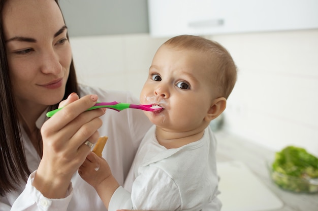 Mother feed cute baby with spoon