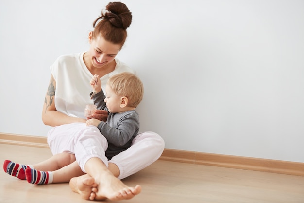 Mother feeding her baby boy with spoon