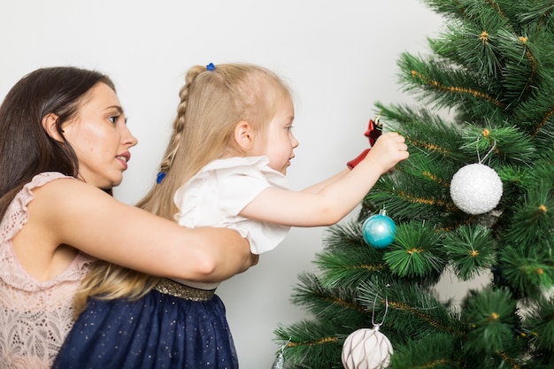 Mother and girl decorating christmas tree