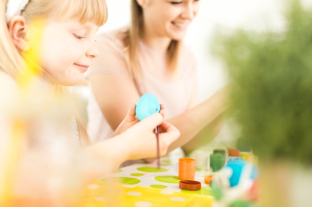 Free photo mother and girl decorating easter eggs