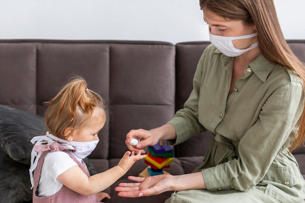 Mother and girl disinfecting hands