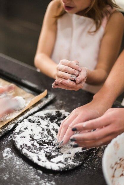 Mother and girl making cookies in kitchen