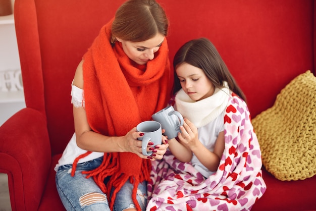 Mother gives her sick daughter hot tea