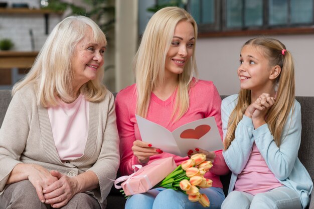 Mother and grandmother are looking at the cute girl