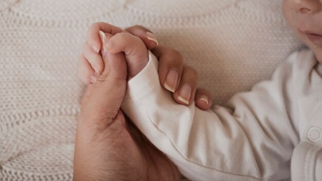 Mother hand holding baby little arm