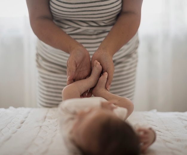 Mother hands playing with baby legs