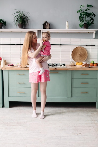 Mother having breakfast with her lovely daughter in the kitchen