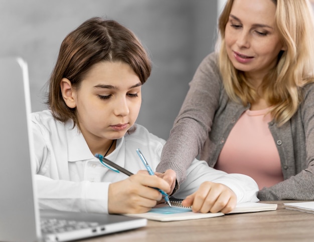 Free photo mother helping daughter to study