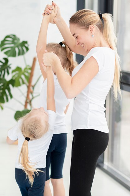 Mother helping daughters exercise at home