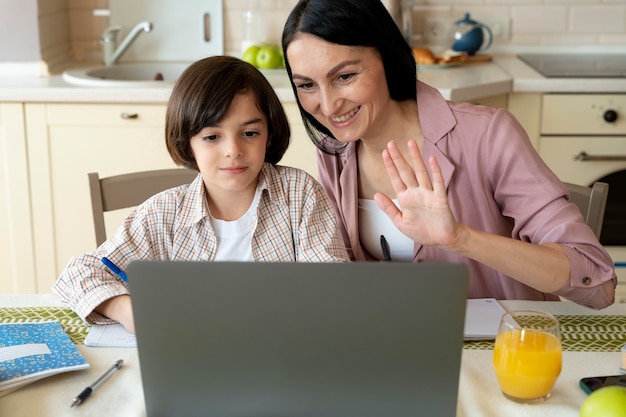 Mother helping her son in an online class